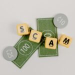 Yellow dice spelling 'Scam' on fake currency, representing financial deception.