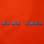 Letters forming 'Bank Loan' on a vibrant red surface, ideal for finance themes.